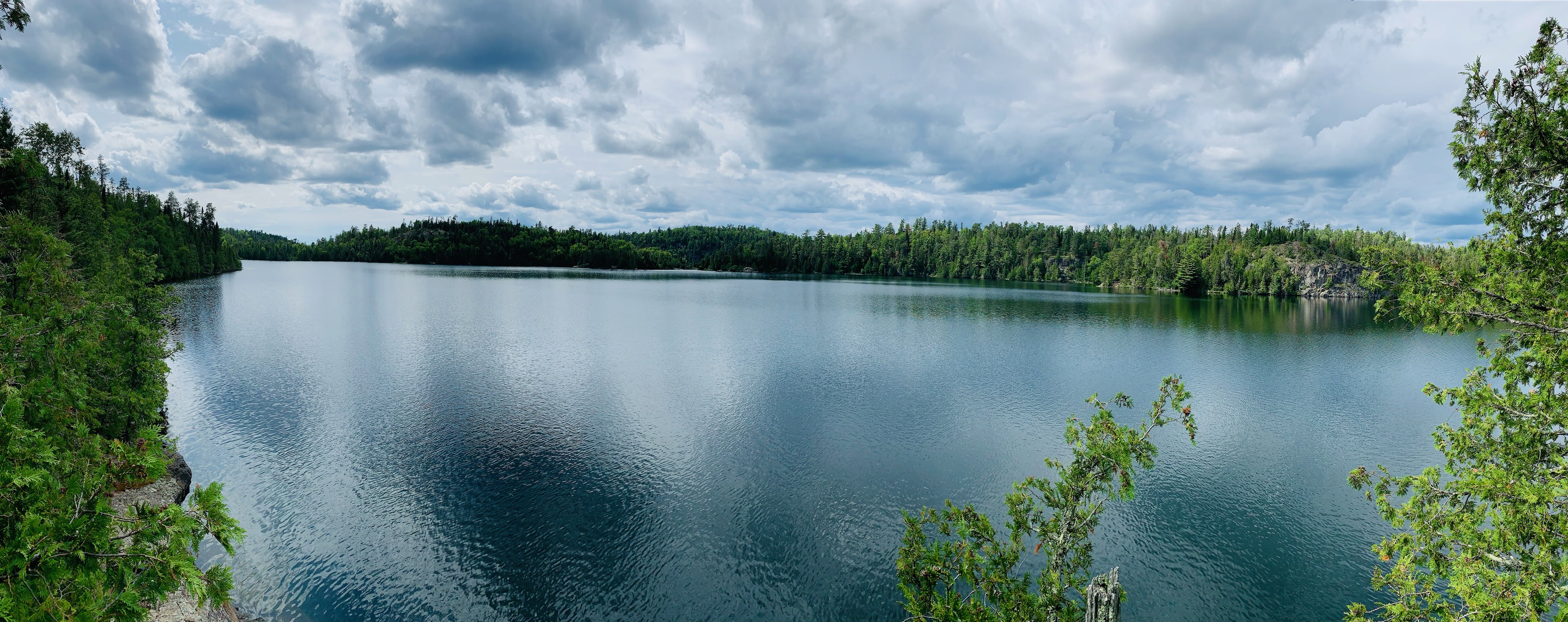 A wide Boundary Waters lake bordered by forest